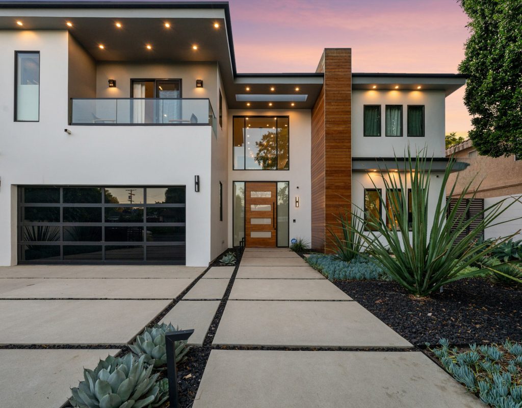 Twilight photo of a modern luxury home with pool, patio, and sleek architectural lines in a suburban setting