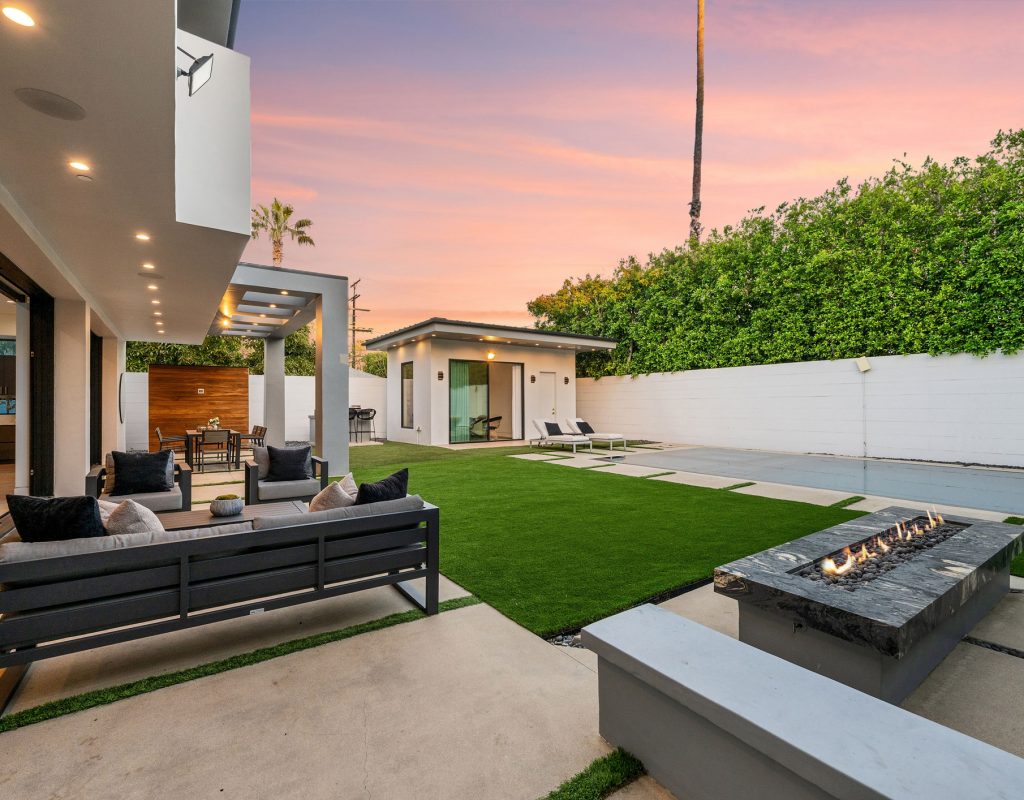 Twilight photo of a modern luxury home with pool, patio, and sleek architectural lines in a suburban setting